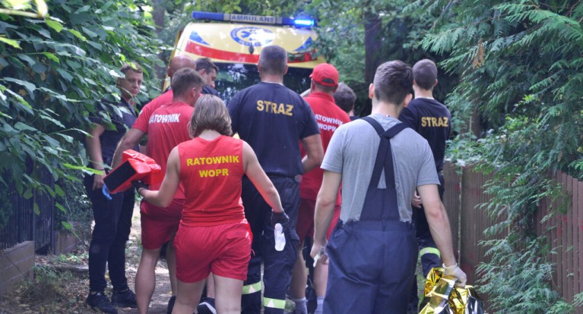 Służby ratunkowe biorące udział w zdarzeniu po udzieleniu pierwszej pomocy podążają do karetki. Ratownicy transportują na noszach poszkodowaną. W ostatnim rzędzie idzie Izabela Jaroszewska. fot. Paweł Lachowicz