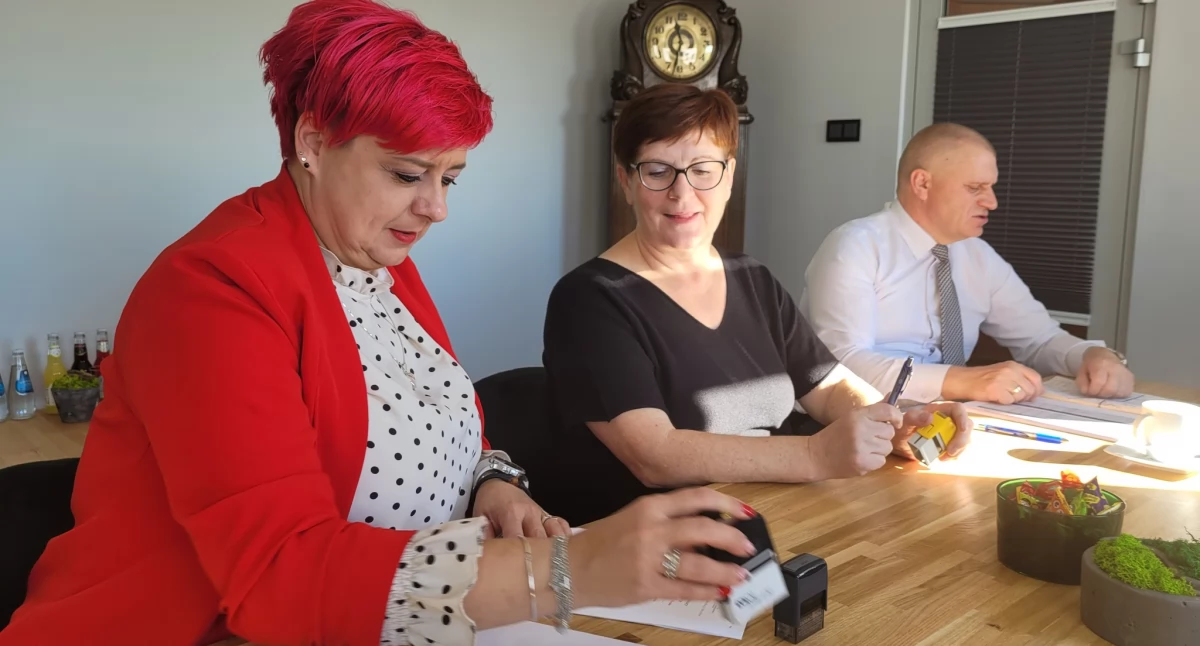 Pani wójt gminy Agnieszka Ziółkowska podpisuje umowę na modernizację dróg gminnych z przedstawicielami firmy Inodrog fot. UG Dąbrowa