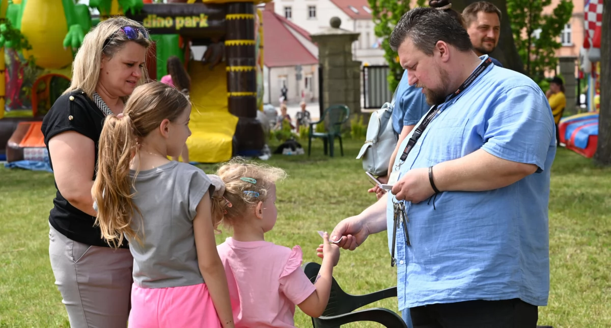 Damian Rybak wręcza dzieciom talony ufundowane przez parafię na bezpłatną watę cukrową fot. Magdalena Lachowicz