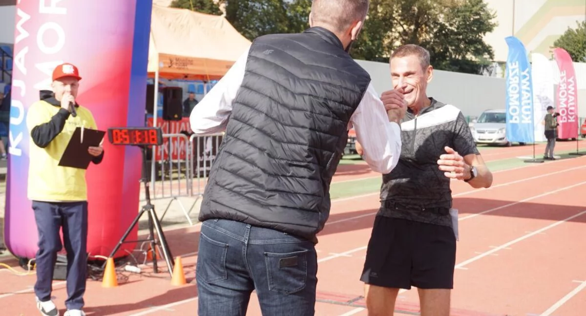 6 października 2024 roku. Leszek Duszyński ukończył właśnie dystans 10 km pod czas Rozbieganego Mogilna. Gratuluje mu na mecie burmistrz Karol Nawrot  fot. Marek Holak