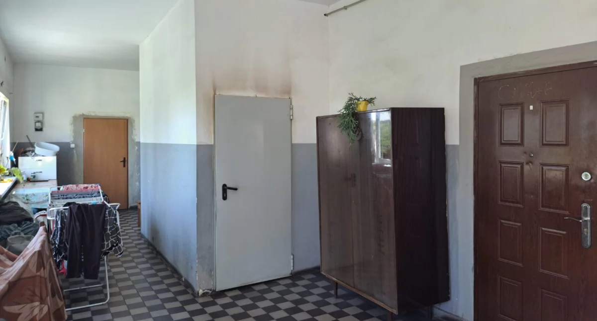 Nad drzwiami wejściowymi do mieszkania komunalnego w Siedlimowie widać zadymioną ścianę korytarza fot. Paweł Lachowicz