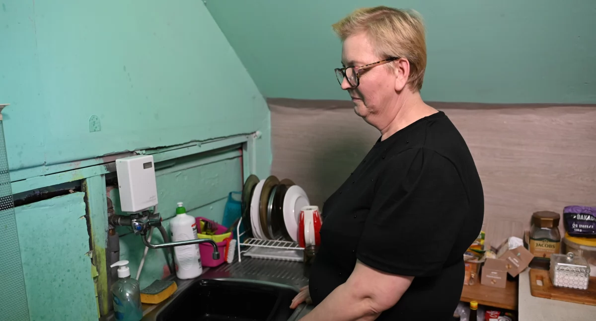 Marlena Karnicka w niewielkim pomieszczeniu o niskim, skośnym stropie zaadaptowanym na kuchnio-toaletę fot. Paweł Lachowicz