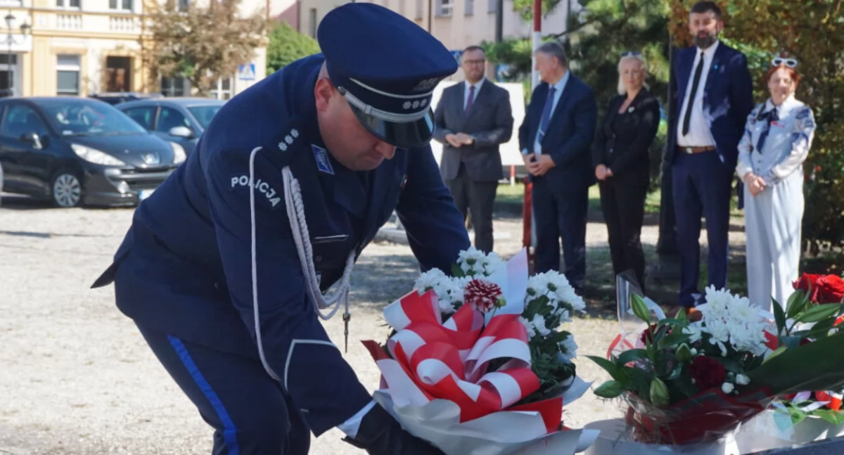 Kwiaty pod Pomnikiem Wdzięczności na rynku składa komendant KPP Mogilno kom. Paweł Kazubowski   fot. Marek Holak