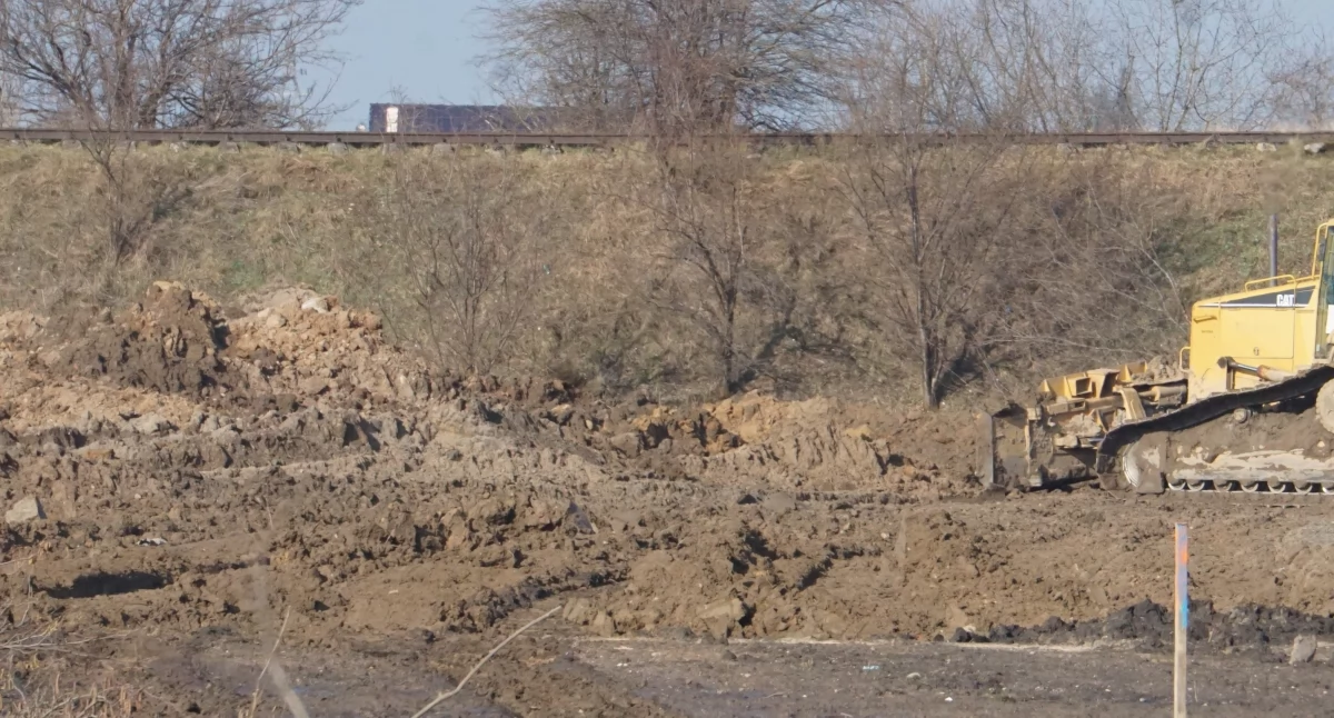 Nawożenie ziemi i wyrównywanie terenu, w miejscu, gdzie później powstały boisko trawiaste i sztuczne kryte balonem. W tle nieczynna linia kolejowa z Mogilna w kierunku Strzelna   fot. Marek Holak